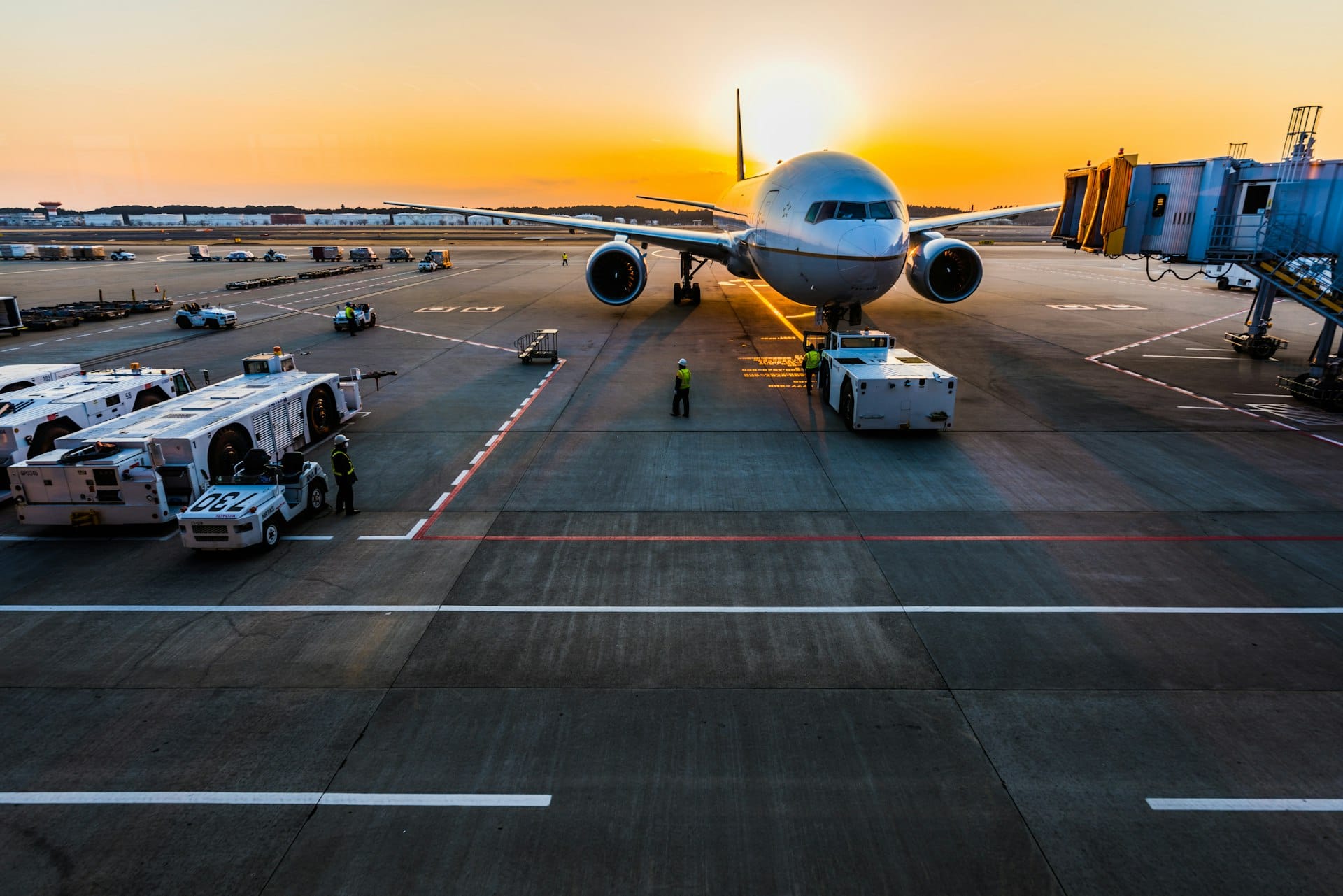 Wide-body aircraft nose-on at an airport apron at sunset