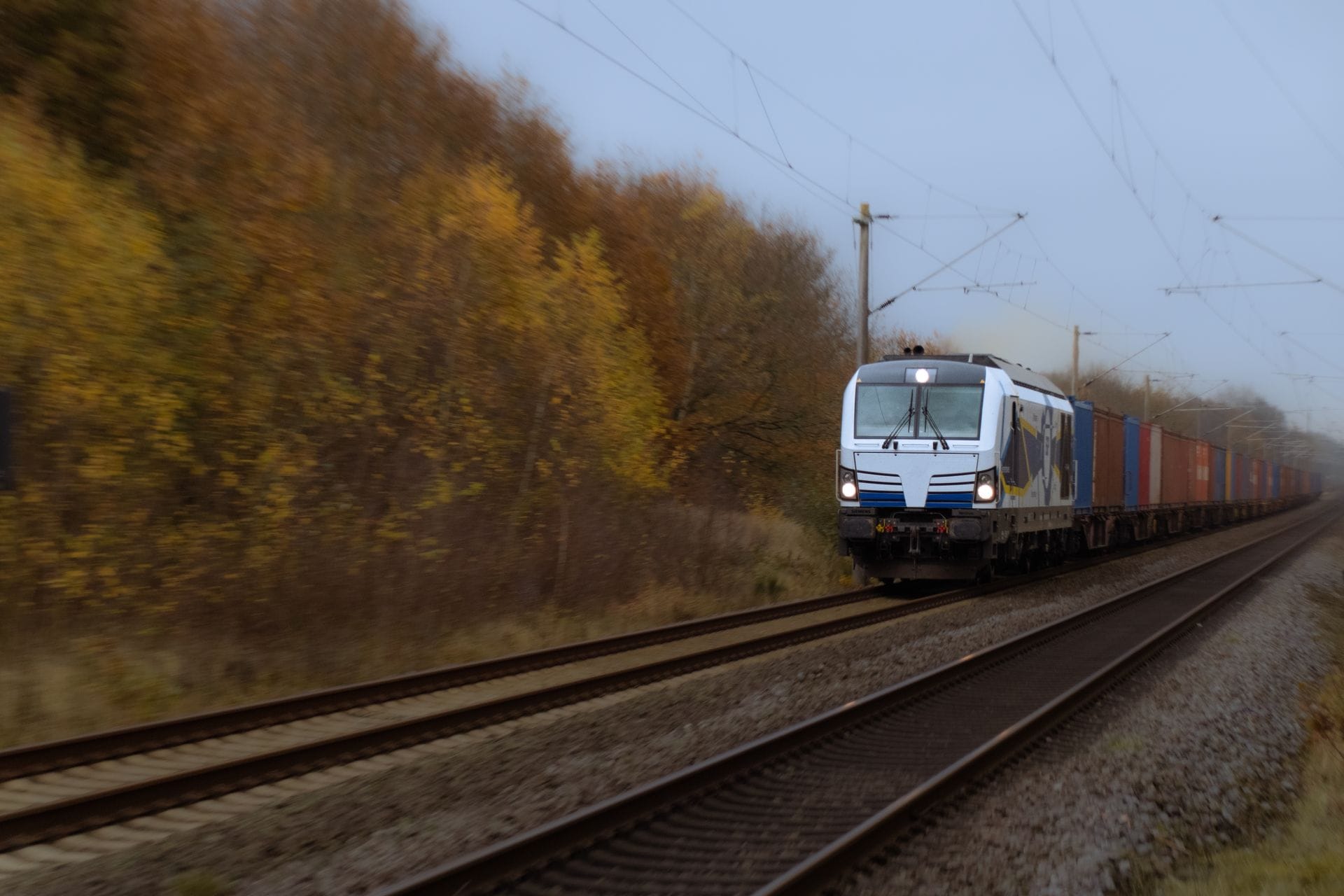 Container-loaded freight train at speed on an electrified line